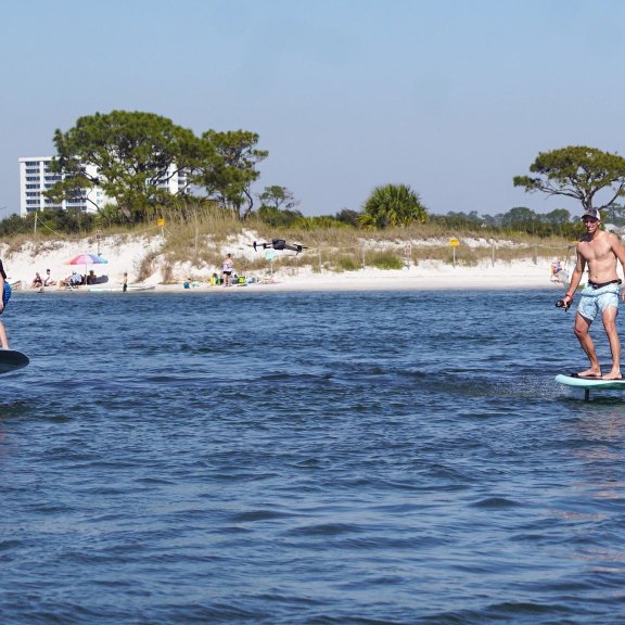 Man and boy efoil boarding in the bay, exciting watersport in Orange Beach