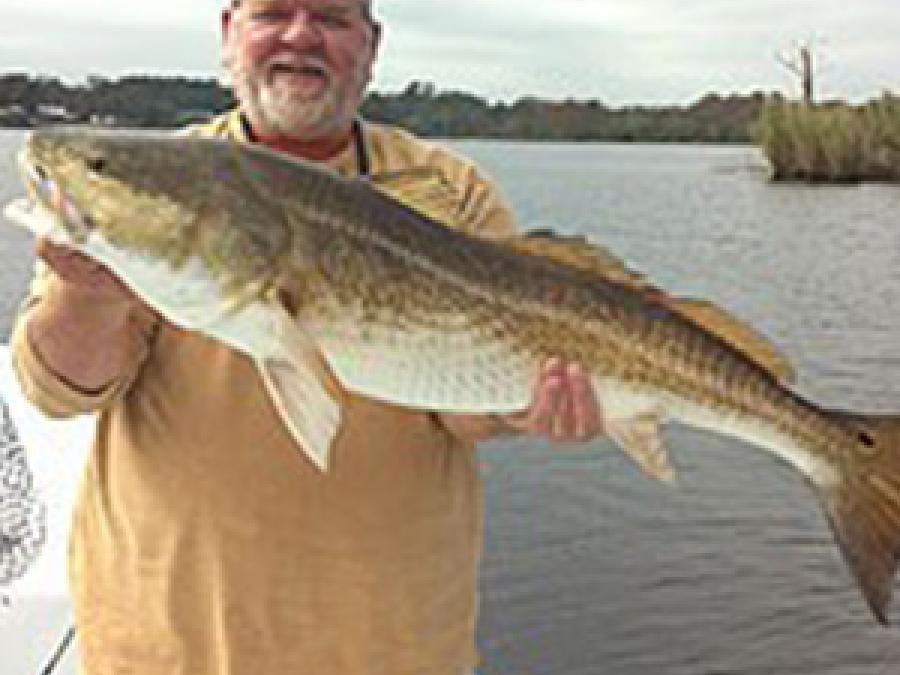 David Rainer on a boat holding a large fish in his hands