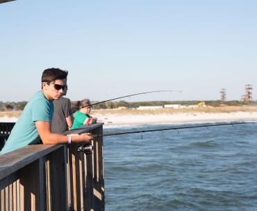 Teen boy fishing off the Gulf State Park Pier in Gulf Shores, AL