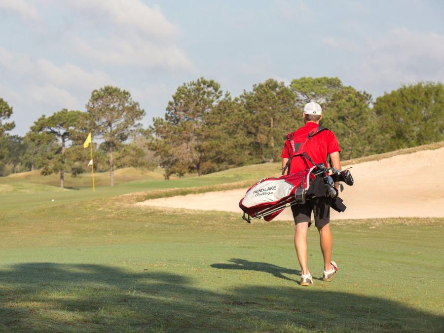 Golfer walking across the green at Craft Farms Golf Resort in Gulf Shores