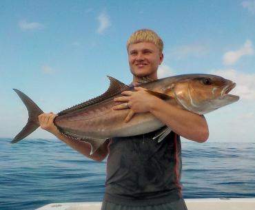 Angler holding an amberjack caught in the Gulf of Mexico