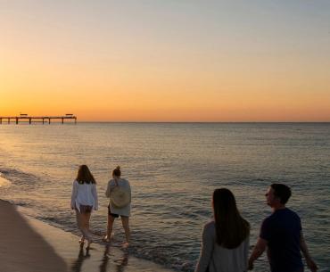 Family walking along the beach at sunrise in Gulf Shores