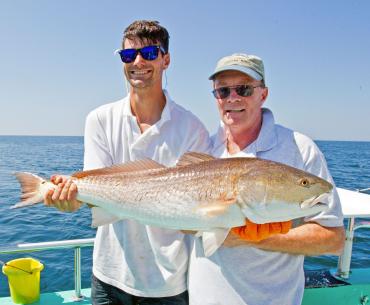 Anglers with a redfish caught in Orange Beach