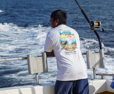 Man on back of boat trolling inthe Gulf of Mexico