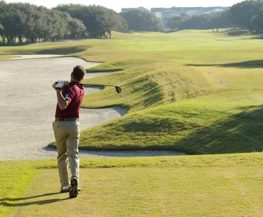 Golfer swinging at Kiva Dunes Golf Resort in Fort Morgan