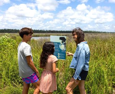 Family reading a sign inside Gulf State Park