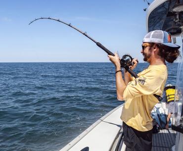 Man fishing off the side of an offshore charter in Orange Beach