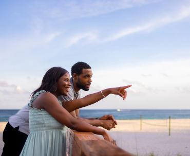Couple on a boardwalk at the beach during sunset in Orange Beach
