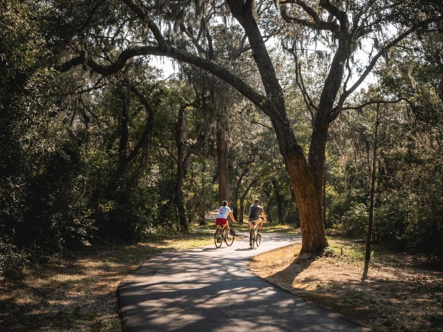 Couple biking along the paved trails in Gulf State Park in Orange Beach