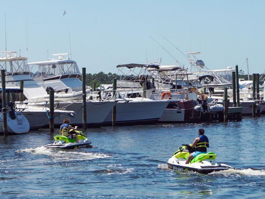Two guys riding Jet skis in the backbays of Orange Beach