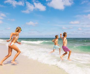 Kids running into the Gulf on the beach in Gulf Shores
