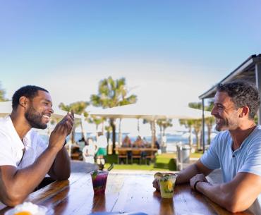 Two men sitting at a table outside at The Gulf waterfront restaurant in Orange Beach