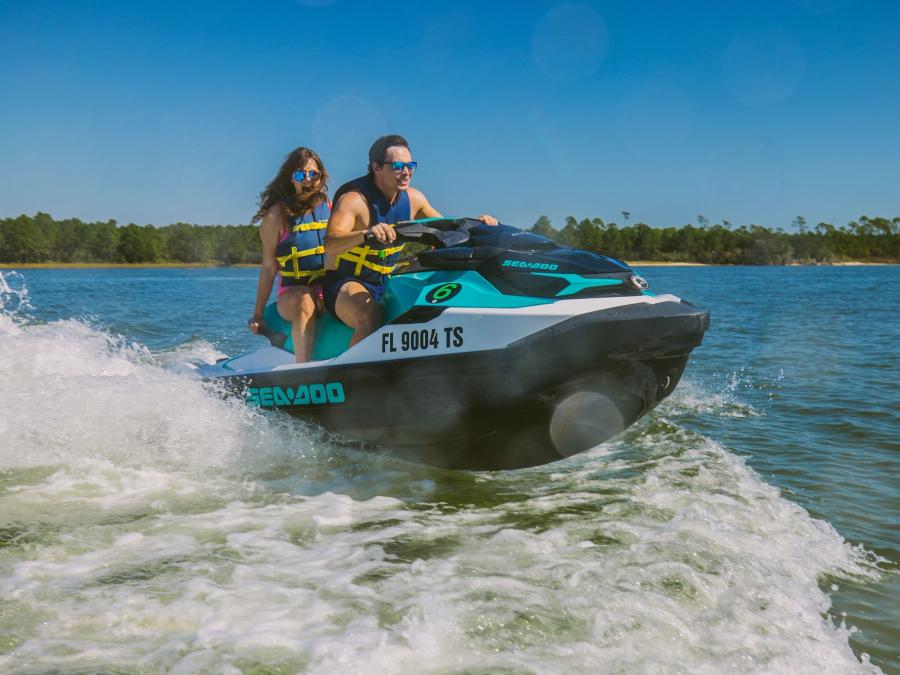 Couple riding a Jet Ski across the water in Orange Beach
