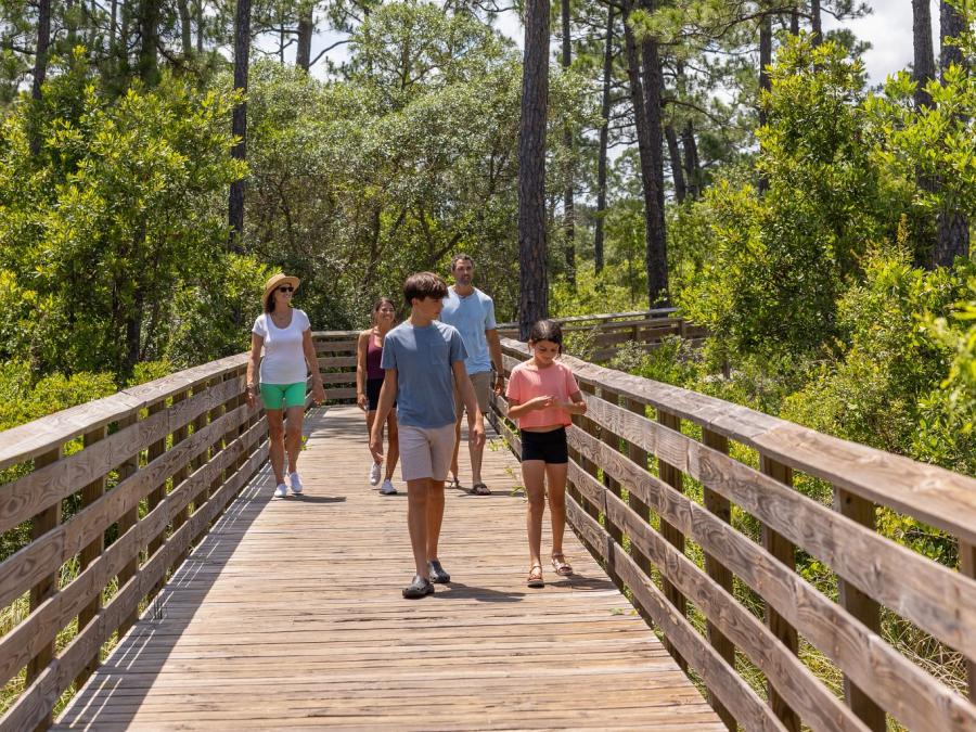 family walking along boardwalk trail in gulf state park