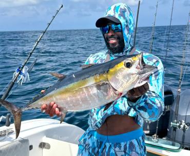 angler holding a tuna caught on a fishing charter in the Gulf