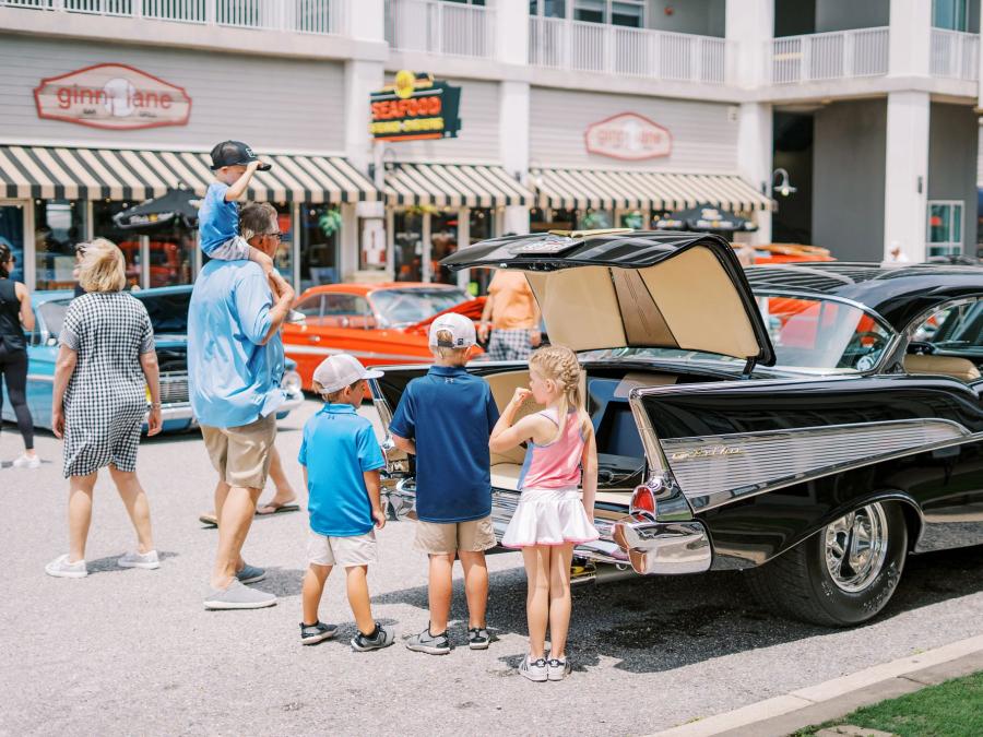 Kids admiring a classic car at the Bama Coast Cruisin' Car Show at The Wharf