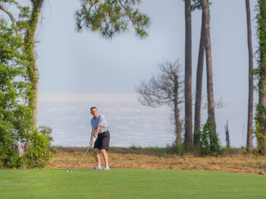 man about to swing his golf club at peninsula golf and racquet club in Fort Morgan