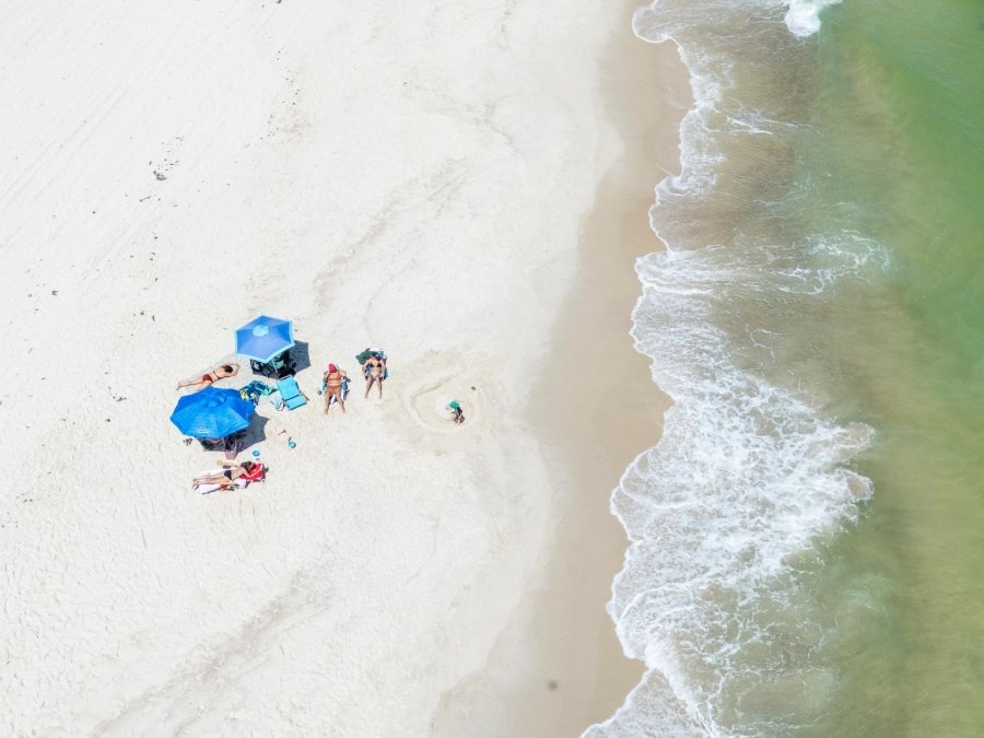 Aerial view of umbrellas and chairs by the shoreline at the beach in Orange Beach