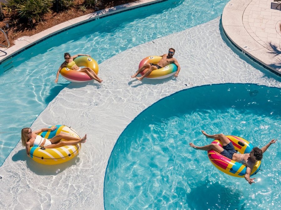 Friends floating on inner tubes in the lazy river at Beach Village Resort in Oragne Beach