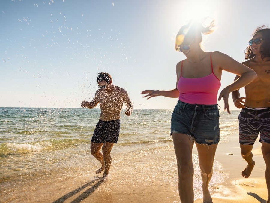 Friends splashing in the water on the beach in Gulf Shores