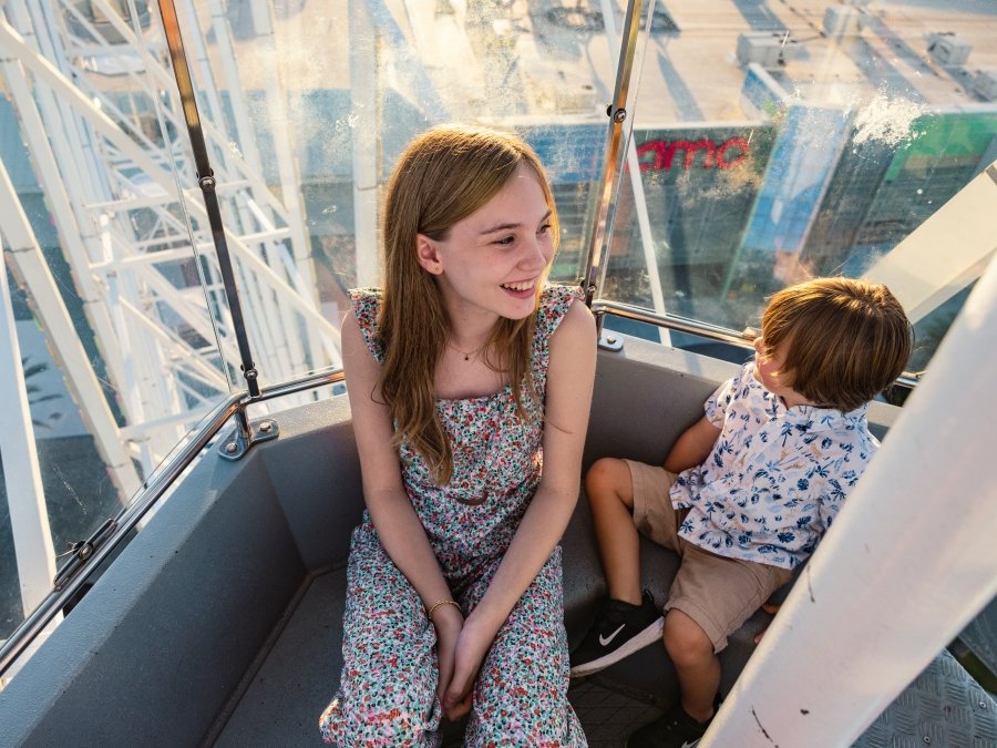 Kids riding The Wharf Ferris Wheel family friendly attraction in Orange Beach
