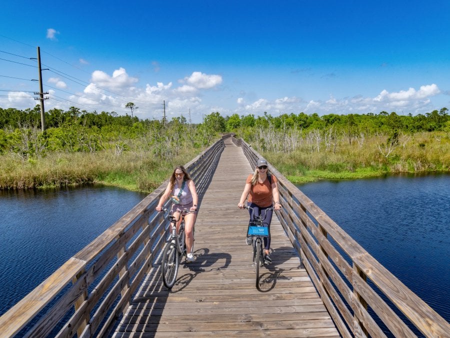 Girls biking along the boardwalk trails in Gulf State Park