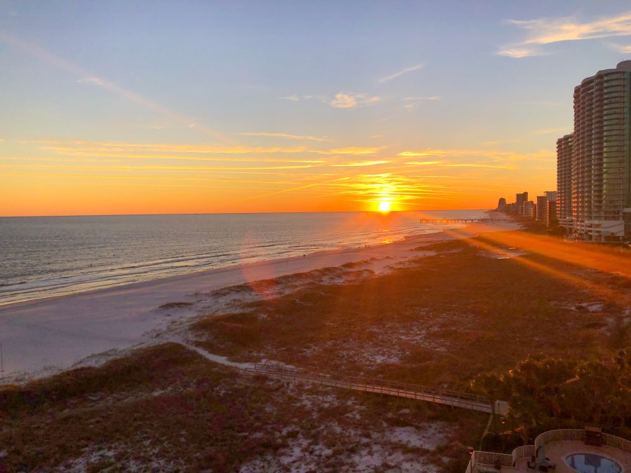 sunset over beach from island house hotel balcony in orange beach
