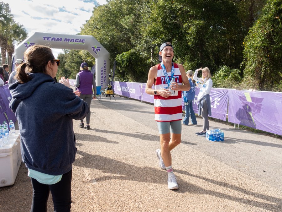 Man crossing the finish line at the Coastal Half Marathon