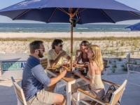 Friends dining at an outdoor table at Coastal beachfront restaurant