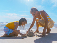 grandma and grandkid playing in the sand in Gulf Shores