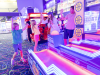 Family playing arcade games at The Track Gulf Shores attraction