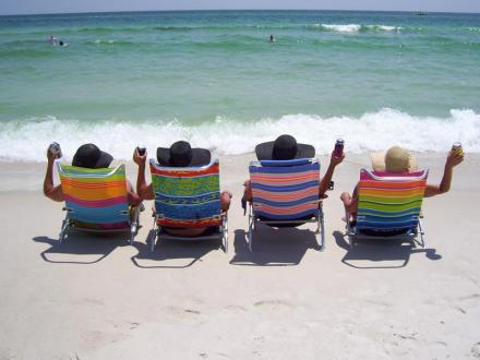 four girls sitting in beach chairs by the shore