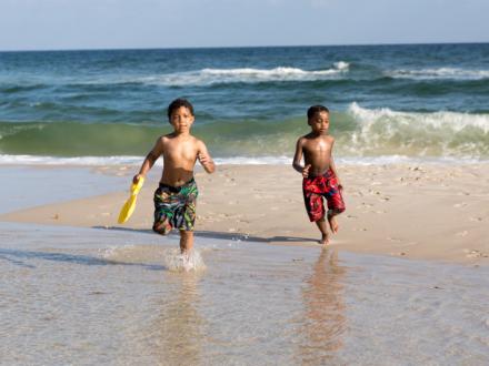 two little boys running on the beach