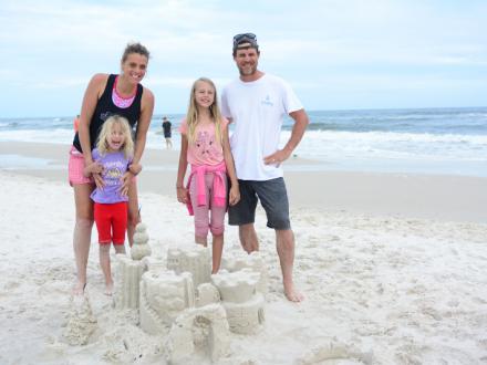 family of four building sandcastles on the beach