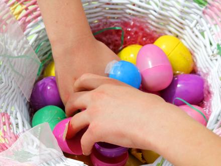Hands reach for Easter eggs in basket