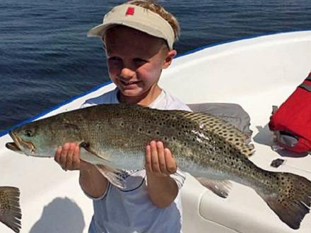boy holding a speckled trout