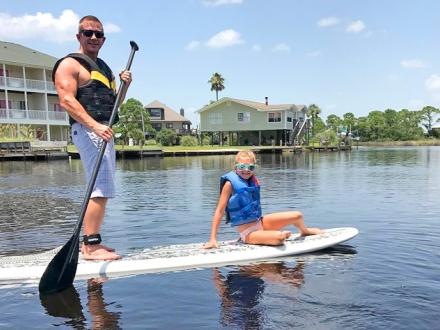 Father and Daughter Paddleboard in Gulf Shores