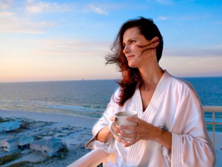 Woman enjoys view from beach balcony