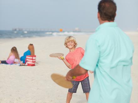family playing on beach