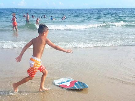 Boy plays with skim board on Alabama's Beaches