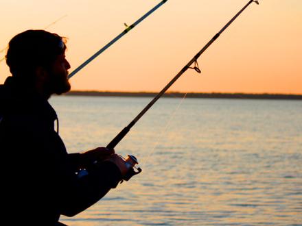 Man fishing from Gulf State Park pier at Sunset
