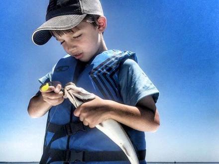 Boy Fishing while wearing life jacket