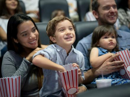 Family watching movie at theater
