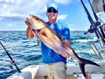 Man holding catch on charter fishing boat in Orange Beach