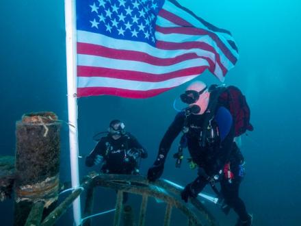 American flog underwater with diver