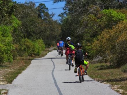 Family biking on the Backcountry Trail in Orange Beach, AL