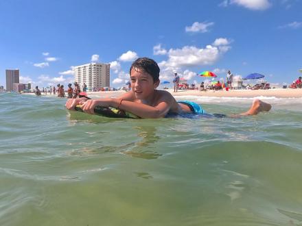 Boy skimboarding in Orange Beach, AL