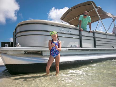 Family on a pontoon boat on Alabama's beaches