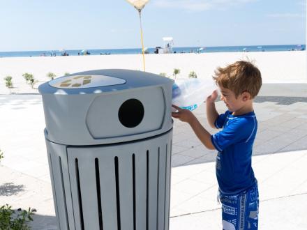 Child throwing away trash on the beaches in Alabama