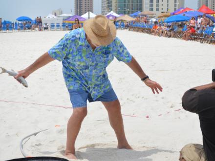 Man tossing a fish at the Mullet Toss